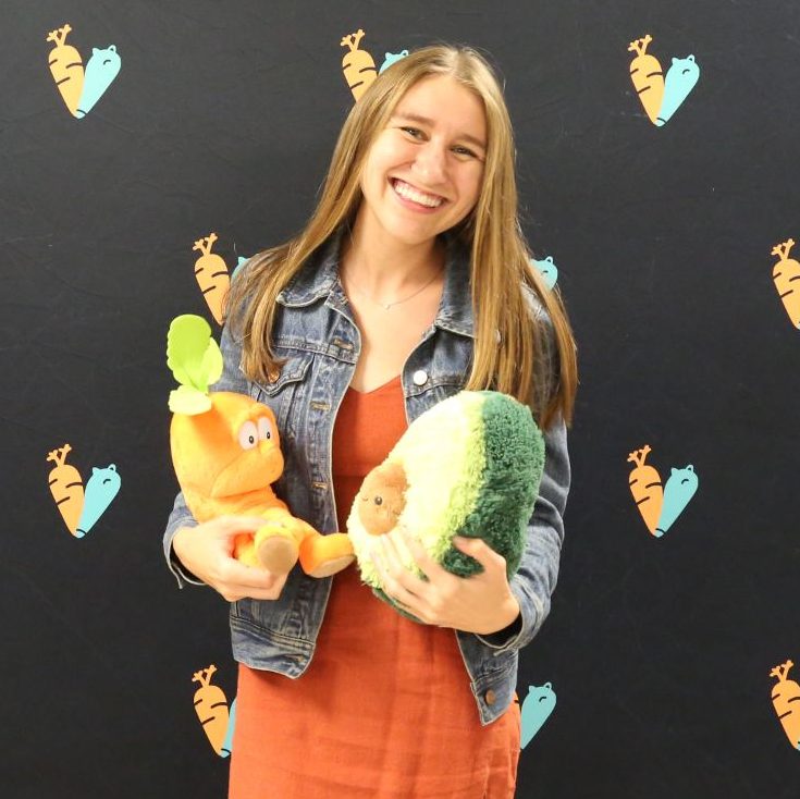 Headshot of Program Coordinator, Keely O'Donnell-Boyd, holding vegetable plushies